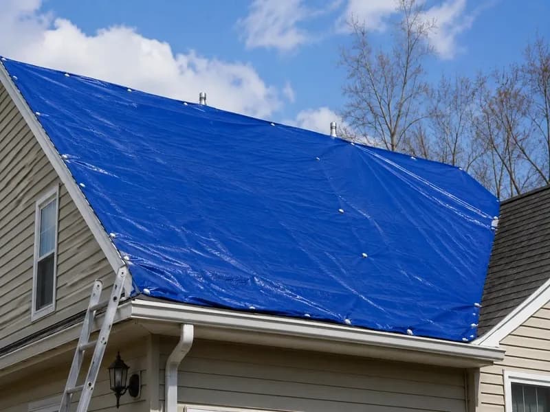 Emergency tarp installed over storm-damaged roof section